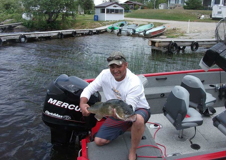 An angler holding a walleye on Dog Lake